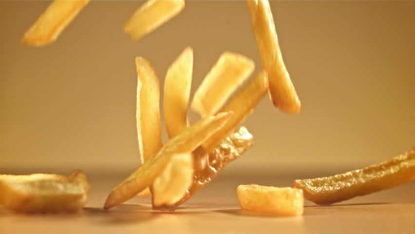 French fries with salt fall on the table. Filmed on a high-speed camera at 1000 fps. High quality FullHD footage