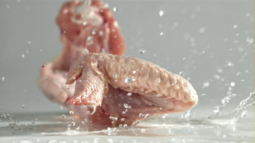 Raw chicken wings falling on white background. Filmed on a high-speed camera at 1000 fps. High quality FullHD footage