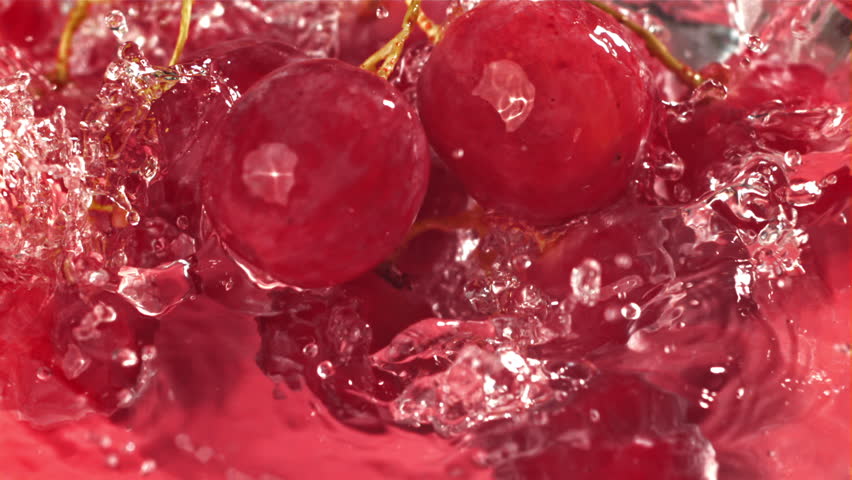 Red grapes fall with splashes into the water. Top view. Filmed on a high-speed camera at 1000 fps. High quality FullHD footage