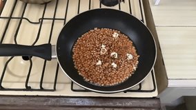 Popcorn kernels starting to pop in a pan.  - Powered by Shutterstock - Get 15% off with code: PIKWIZARD15