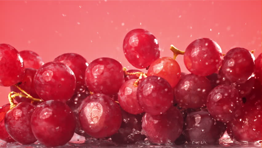 Red grapes fall with splashes on a wet table. Filmed on a high-speed camera at 1000 fps. High quality FullHD footage