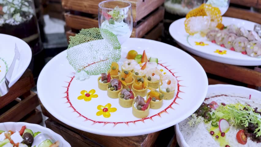 High-resolution 4K close-up of a beautifully arranged gourmet appetizer platter with shrimp, rolled bites, mousse dessert, and decorative plating—perfect for food promos and culinary reels.