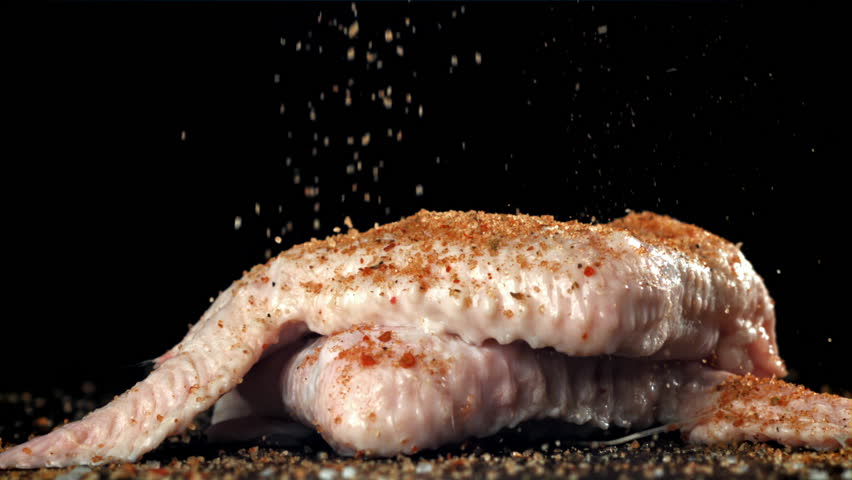 Spices fall on raw chicken wings. Filmed on a high-speed camera at 1000 fps. High quality FullHD footage