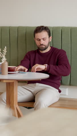 Man, watch and check time at cafe for business meeting, client delay or late for appointment. Waiting, freelance consultant or wristwatch in restaurant for schedule, impatient or thinking of deadline