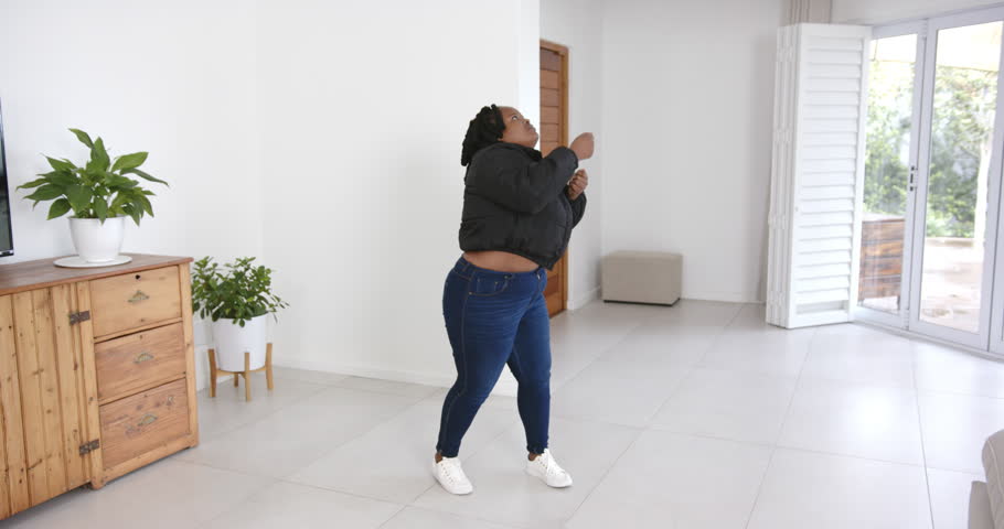 High speed photography for dynamic scenes, Enjoying music, woman dancing enthusiastically in modern living room.