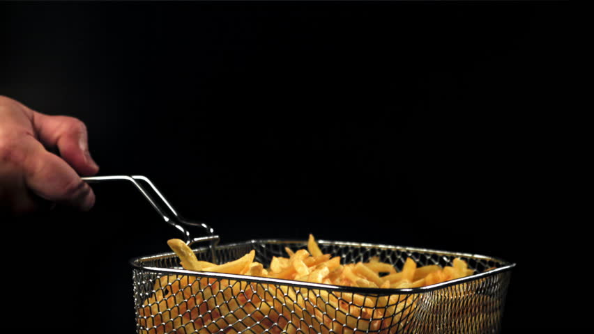 French fries in a deep-frying net in the chef