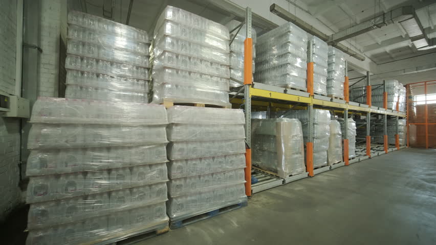 Stacked Pallets with Plastic Bottles in Warehouse Storage