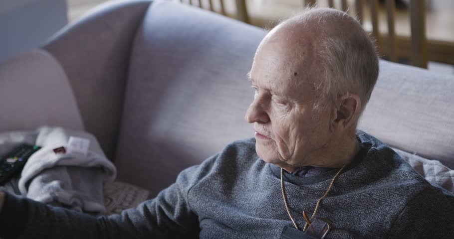 Senior man drink medicine pills with a glass of milk or supplement capsule on sofa in home. Elderly male in recovery with a pill or medical prescription drug for health, wellness or pain antibiotics