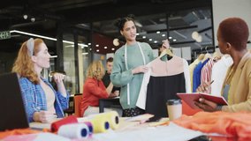 Fashion designers gathering in studio arranging fabric rolls and dress sample, with emoji overlays. Collaboration, creative, innovation, workspace, style, industry, development - Powered by Shutterstock - Get 15% off with code: PIKWIZARD15