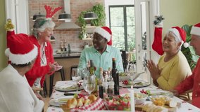 Senior friends celebrating holiday marketing around dinner table, with floating emoji reactions. Festive, celebration, seniors, gathering, holiday, dining, cheerful - Powered by Shutterstock - Get 15% off with code: PIKWIZARD15