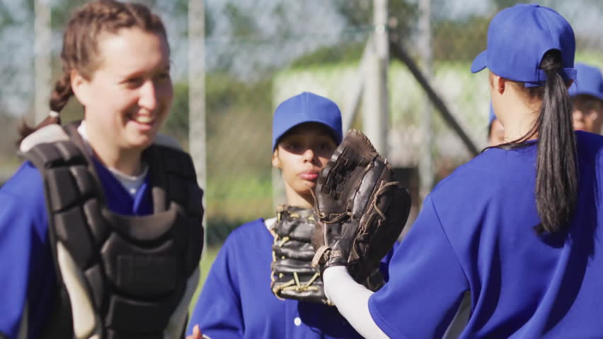 Female softball players posing on field, showing heart icon emoji overlay for sports marketing. Athletics, teamwork, camaraderie, sporty, outdoor, vibrant, empowerment