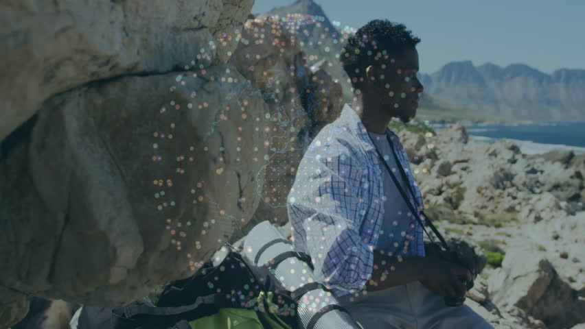 man adjusting camera settings on rocky shoreline, with dynamic animated photography histogram graph. Adventure, exploration, landscape, outdoor, rugged, serenity, hobbyist