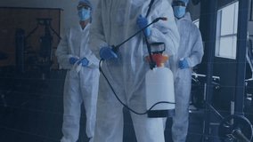 Sanitation team members spraying disinfectant wand in gym, showing digital grid hexagon overlay. Disinfection, sanitation, protective gear, hygiene, digital interface, industrial, cleanliness - Powered by Shutterstock - Get 15% off with code: PIKWIZARD15