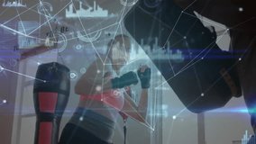 Woman punching heavy bag in gym, displaying digital interface graphics for fitness tech. Fitness, athleticism, high-tech, training, innovation, modernization, strength - Powered by Shutterstock - Get 15% off with code: PIKWIZARD15