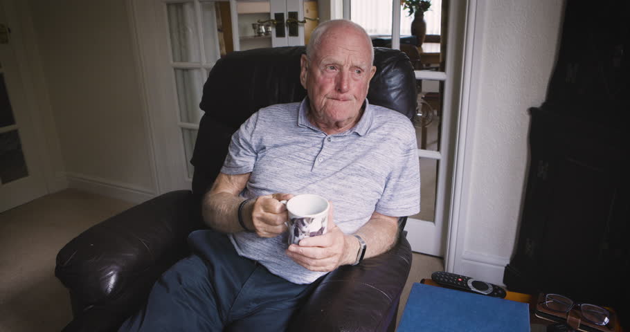Senior man, thinking and drinking coffee in house and nursing home living room with past memory, retirement planning and ideas. Elderly, tea cup and hot drink on armchair furniture in relax apartment