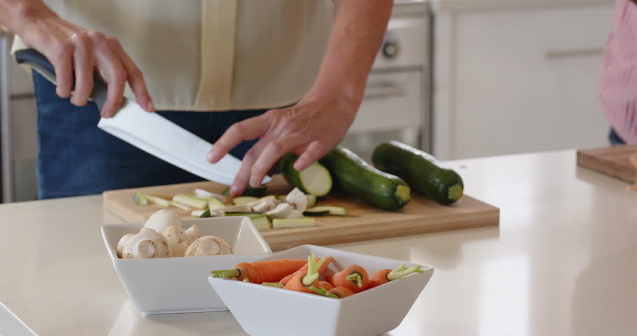 Lifestyle videos indoor of people doing activities at home, Chopping vegetables on cutting board, person preparing meal in kitchen. Cooking, meal preparation, ingredients, food, healthy eating,