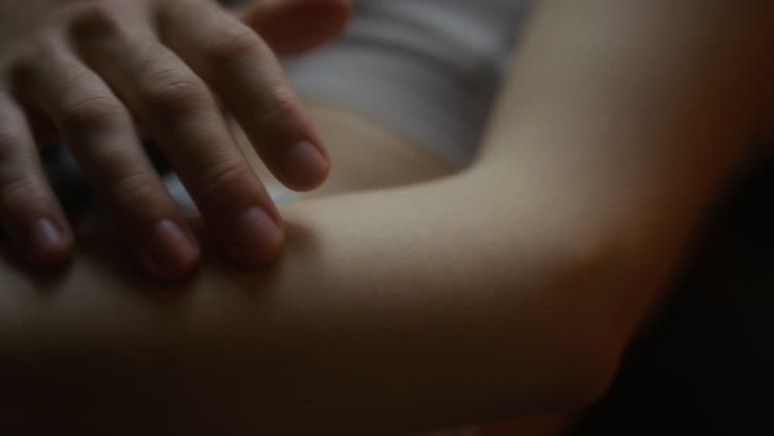 Close-up tracking shot of male fingers slowly running over pale-skinned arm of girlfriend, intimate moments of couple in love