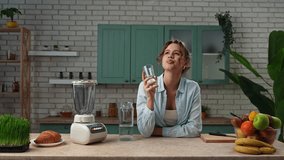 Healthy eating concept. Young woman at the table in the kitchen preparing healthy breakfast, comes to room, pouring clear water in the glass and takes a sip, starting morning with water. Slow motion - Powered by Shutterstock - Get 15% off with code: PIKWIZARD15