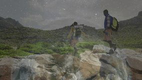 Hiking couple reaching across mountain gap at night showing animated headlamp trails for travel ads. Adventure, exploration, wilderness, rugged, celestial, outdoor, teamwork - Powered by Shutterstock - Get 15% off with code: PIKWIZARD15