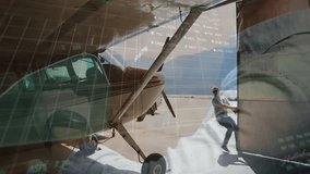 Pilot pulling open hangar door on airport apron, digital financial graphs floating over airplane. Aviation, logistics, transportation, modern, technological, industry, travel - Powered by Shutterstock - Get 15% off with code: PIKWIZARD15