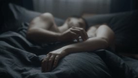 Close-up of young spouses intertwining fingers and holding hands while peacefully snuggling in bed after sleep in morning, deep love, affection and intimacy, focus of hands - Powered by Shutterstock - Get 15% off with code: PIKWIZARD15