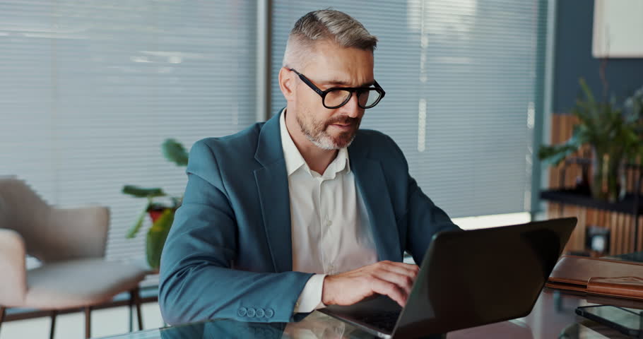 Stress, laptop and business man in office with tension for problem, financial crisis and debt review. Company, corporate and mature person with pressure, frustrated and worry for mistake or deadline