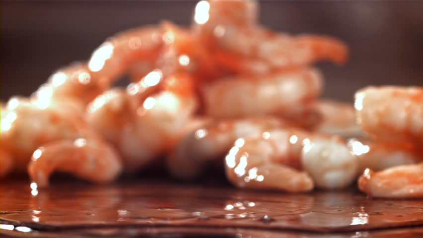 The shrimp falls on a wooden cutting board. Filmed on a high-speed camera at 1000 fps. High quality FullHD footage