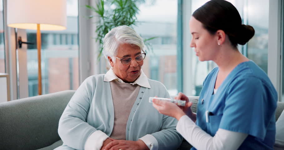 Senior woman, nurse and pills on couch for discussion, guide and listening for medicine schedule in lounge. Elderly person, caregiver and pharmaceutical drugs with talking on sofa in retirement home