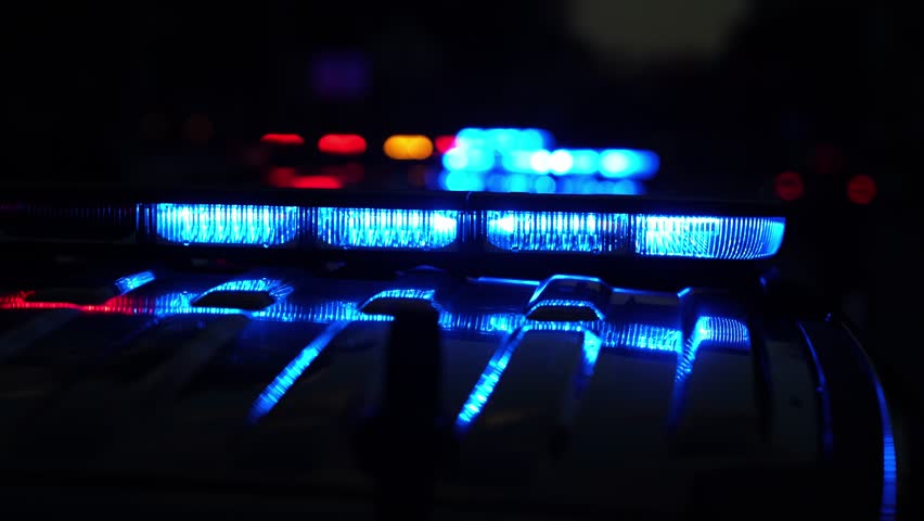 Police car flashing. Crime scene at night. Patrol vehicle outdoors. Emergency lights glowing. Flashing police siren. Police car vehicle. Law enforcement. City night patrol. Police arrest.