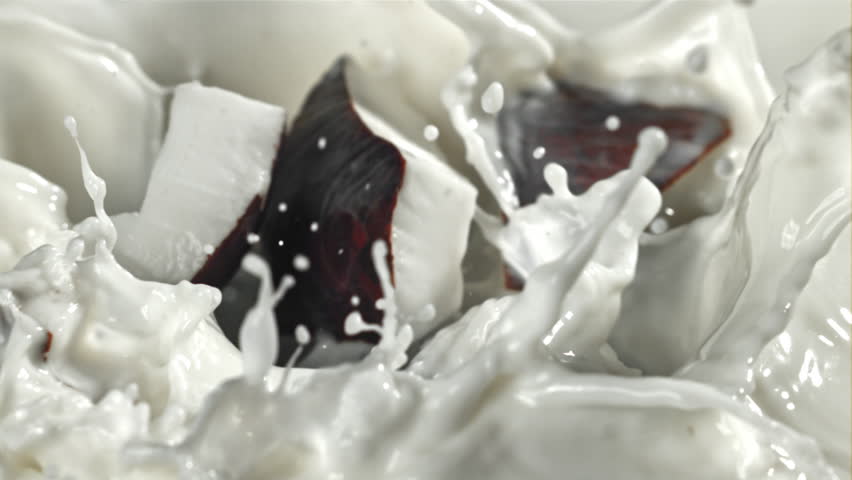 Pieces of coconut fall into the milk with splashes. Filmed on a high-speed camera at 1000 fps. High quality FullHD footage