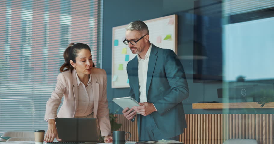 Business people, tablet and cooperation in office, laptop and digital app for online tax schedule. Employees, man and woman in workplace, research and accounting with investment, planning or internet