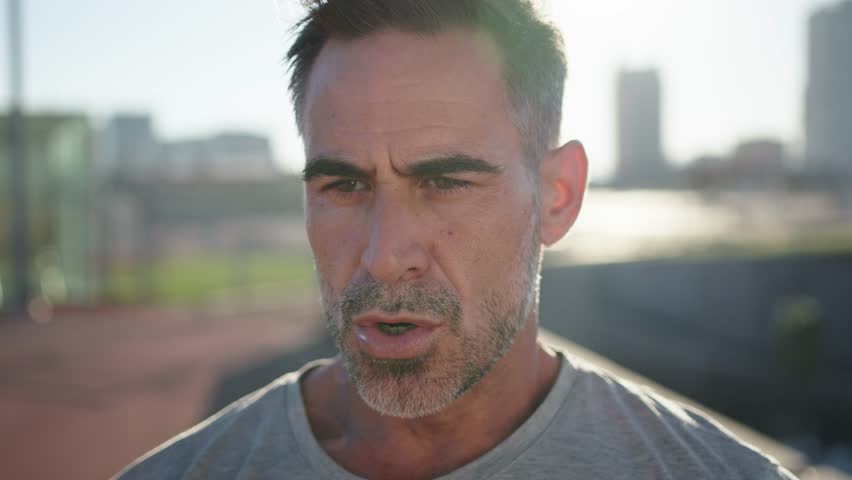 Adult man, runner and breathing for fitness wellness and resting after outdoor cardio workout in city. Tired Caucasian male, breath hard and sports health training vision for marathon motivation