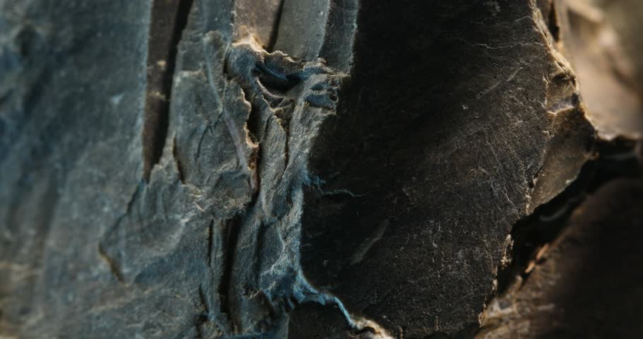 Close-up of broken slate rock with sharp vertical splits and textured layers