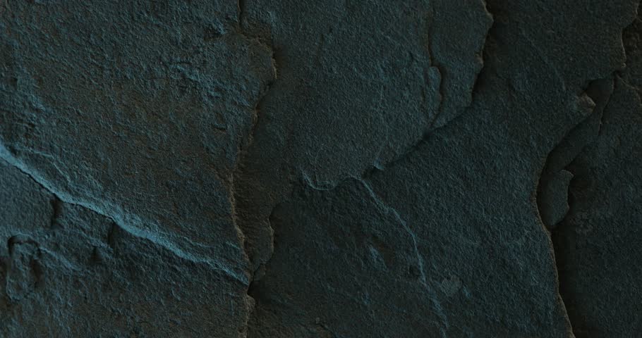 Close-up of cracked dark rock surface with soft lighting and layered texture