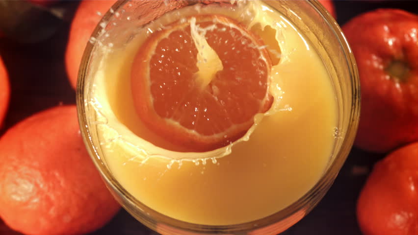 A slice of tangerine falls into the juice with splashes. Filmed on a high-speed camera at 1000 fps. High quality FullHD footage