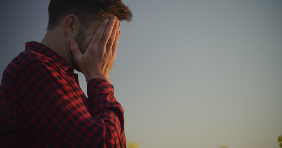 Close-up of a farmer's face expressing sadness, disappointment, and unhappiness due to significant farm losses.