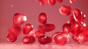 Pomegranate seeds fall on the table with splashes. Filmed on a high-speed camera at 1000 fps. High quality FullHD footage - Powered by Shutterstock - Get 15% off with code: PIKWIZARD15