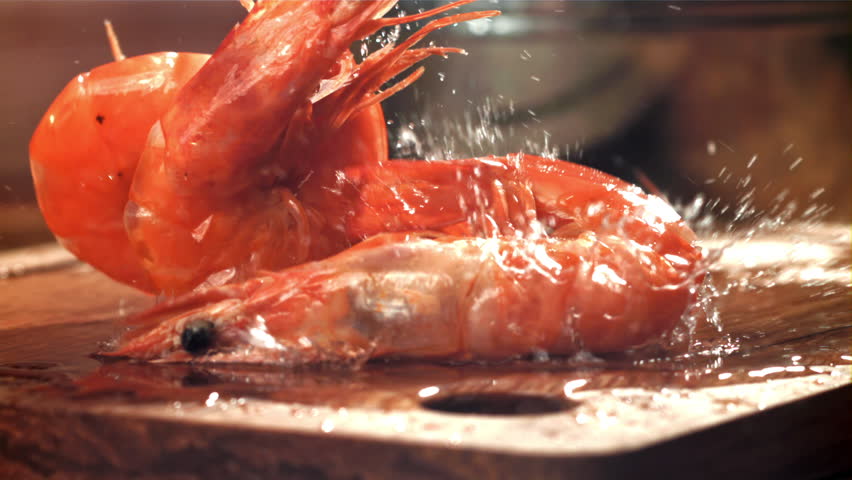 The shrimp falls on a wooden cutting board. Filmed on a high-speed camera at 1000 fps. High quality FullHD footage