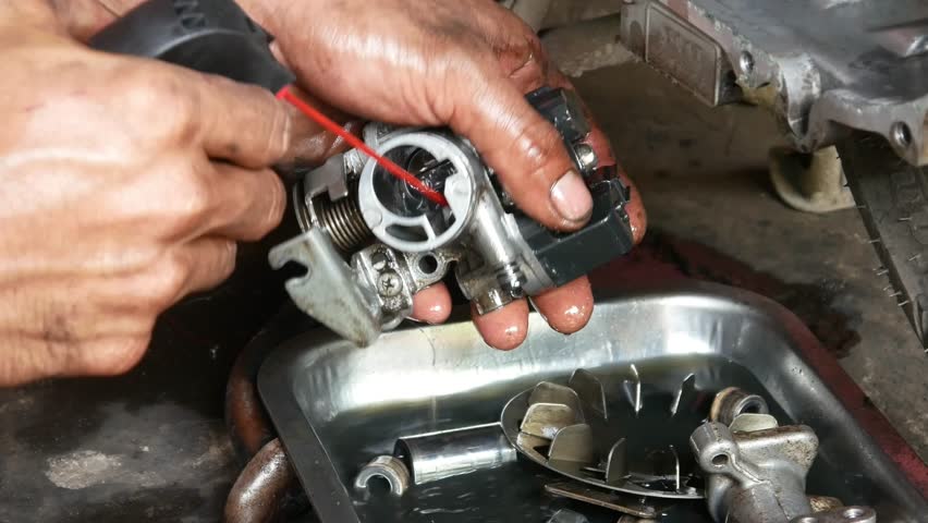 A mechanic performs repairs, maintenance and cleaning on the CVT components of a motorbike
