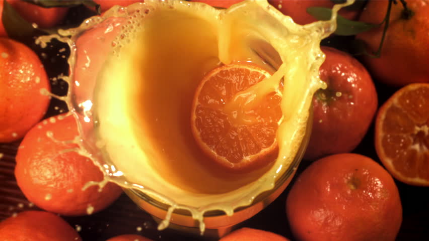 A slice of tangerine falls into the juice with splashes. Filmed on a high-speed camera at 1000 fps. High quality FullHD footage