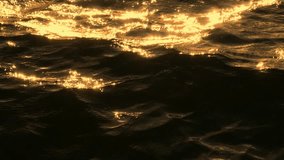 A close-up of the ocean's surface at sunset, where the waves reflect golden sunlight, creating an abstract pattern of motion and light, beautifully captured in slow motion.
 - Powered by Shutterstock - Get 15% off with code: PIKWIZARD15
