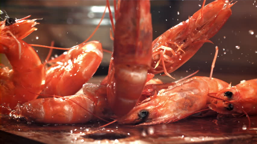 The shrimp falls on a wooden cutting board. Filmed on a high-speed camera at 1000 fps. High quality FullHD footage