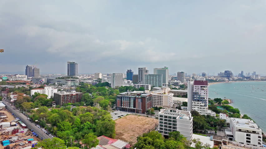 Pattaya city with beach, many boats in the sea and many buildings. It is a landmark and a popular destination.