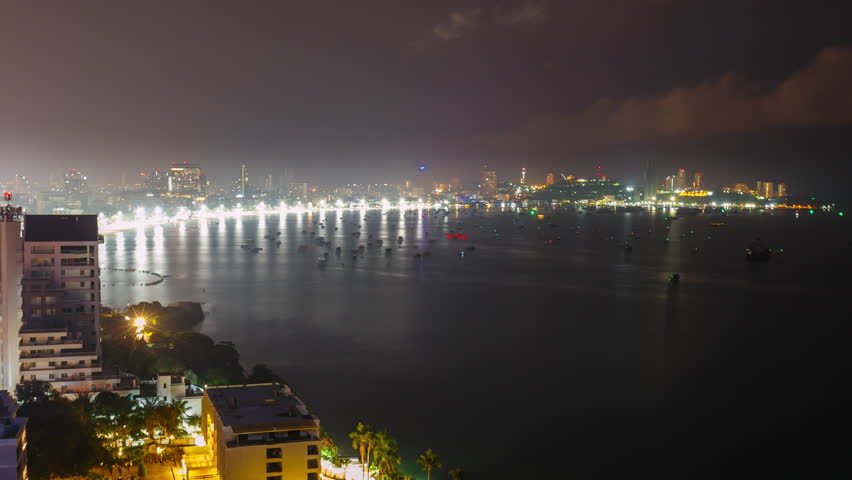 Time lapse of Pattaya city with beach, many boats in the sea and many buildings in the morning sunrise. It is a landmark and a popular destination.