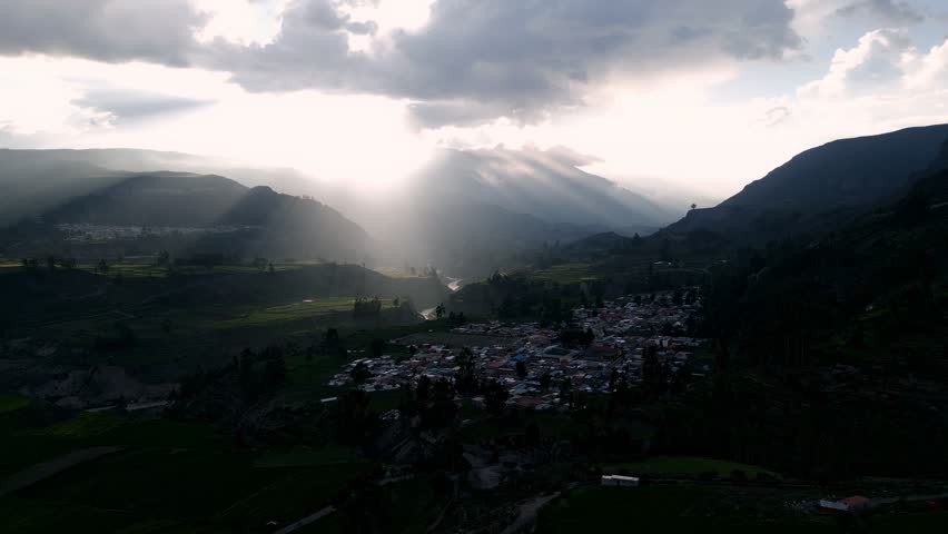 Stunning aerial footage capturing the vibrant colors of sunset over Colca Valley, with the Colca River meandering through the breathtaking landscape. The perfect golden hour view of the Peruvian Andes