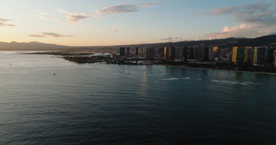 Aerial Shot Flying Over Waikiki at Sunset, Blue Pacific Waves and Honolulu Cityscape