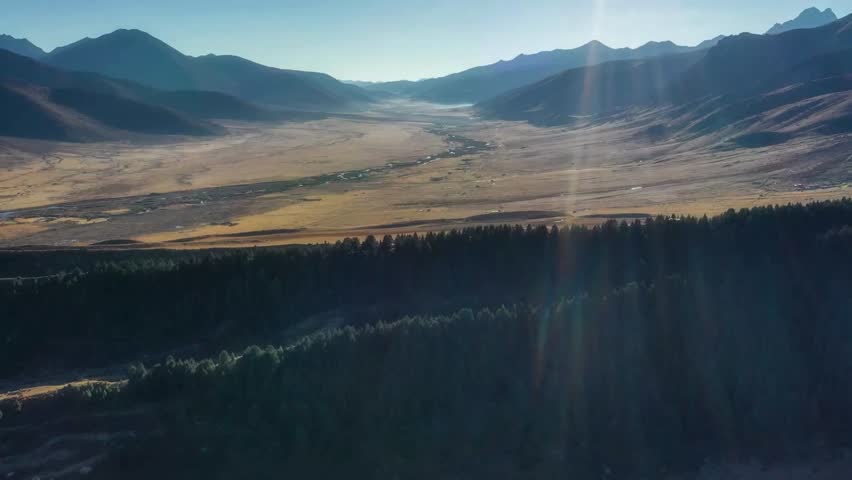 Aerial View of Sun Rays Illuminating Mountain Valley Landscape