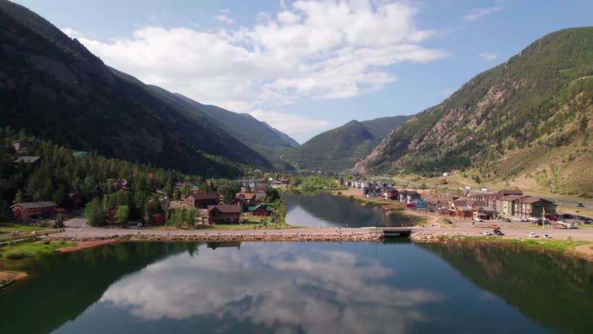 This is an aerial video of the town of Georgetown Colorado. The camera rises and advances revealing Georgetown Lake and the city of Georgetown .
