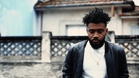 One thoughtful young black walks forward in urban setting contemplating life while strolling outdoors in monochromatic, black and white. Tracking shot of a pensive 20s person, moody introspection - Powered by Shutterstock - Get 15% off with code: PIKWIZARD15