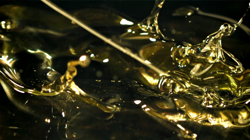 Olive oil with splashes on black background. Filmed on a high-speed camera at 1000 fps. High quality FullHD footage